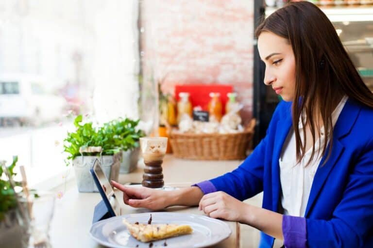 Mujer dejando su opinión en Google My Business a través de una tablet en un negocio de Valencia