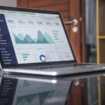 Portátil mostrando datos y gráficas de análisis SEO sobre una mesa de trabajo