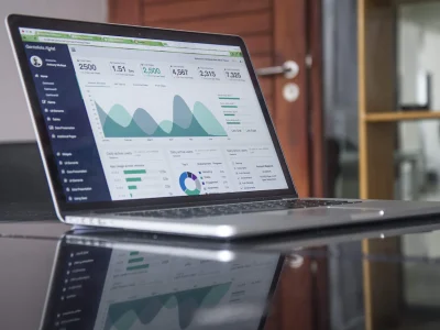 Portátil mostrando datos y gráficas de análisis SEO sobre una mesa de trabajo